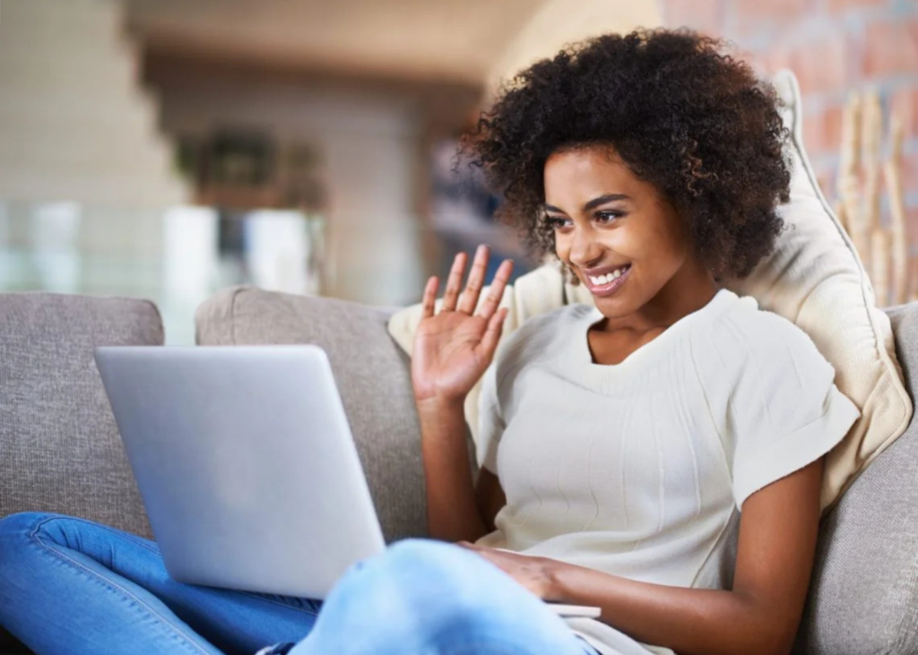 woman smiling and waving at her laptop